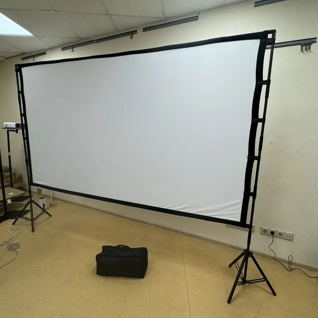 Экран SHAKACHU FWK-P 120″ на двух стойках-треногах в шоуруме, рядом сумка для переноски